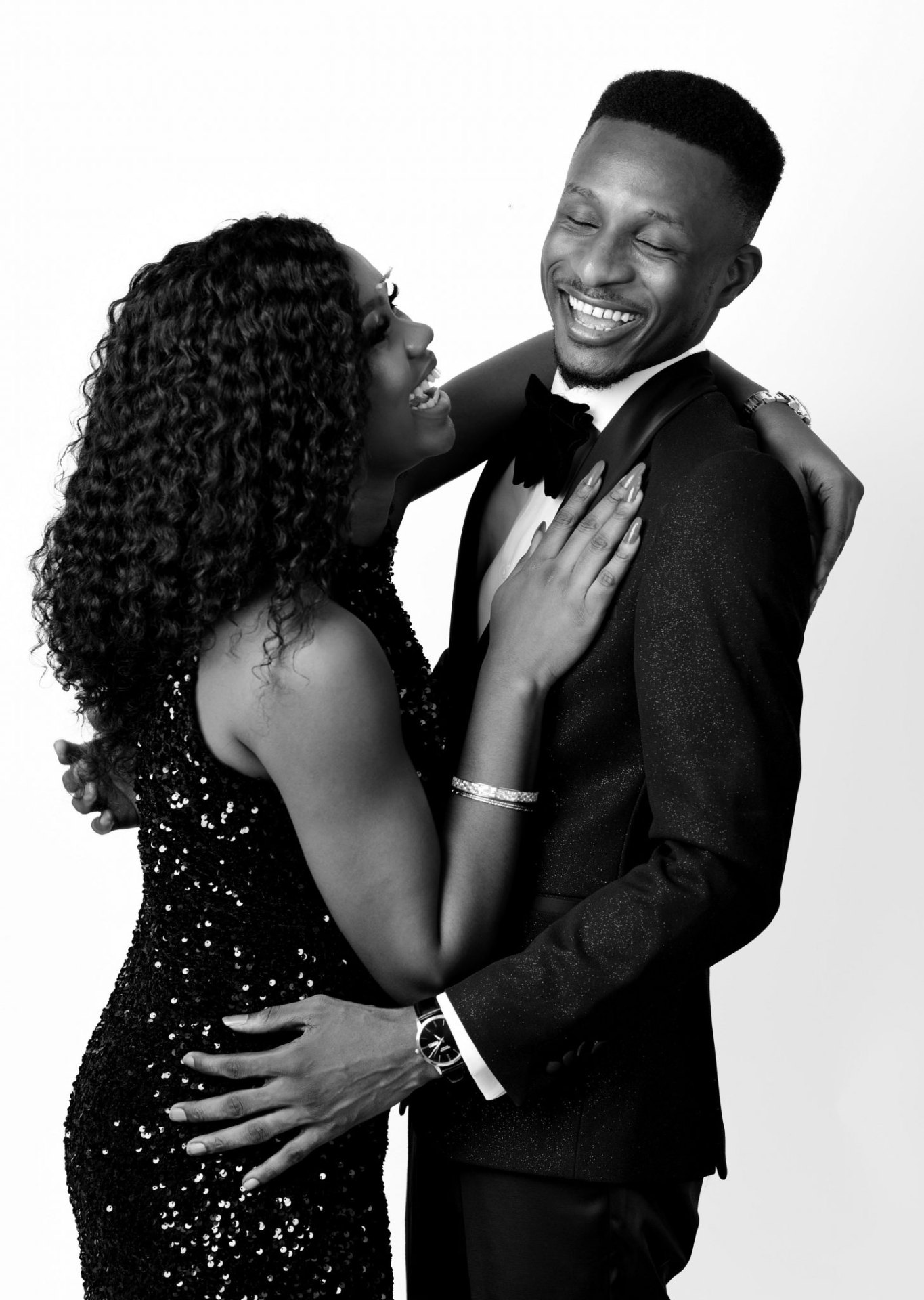 Black and white portrait of Dami laughing with her husband, both in formal wear.